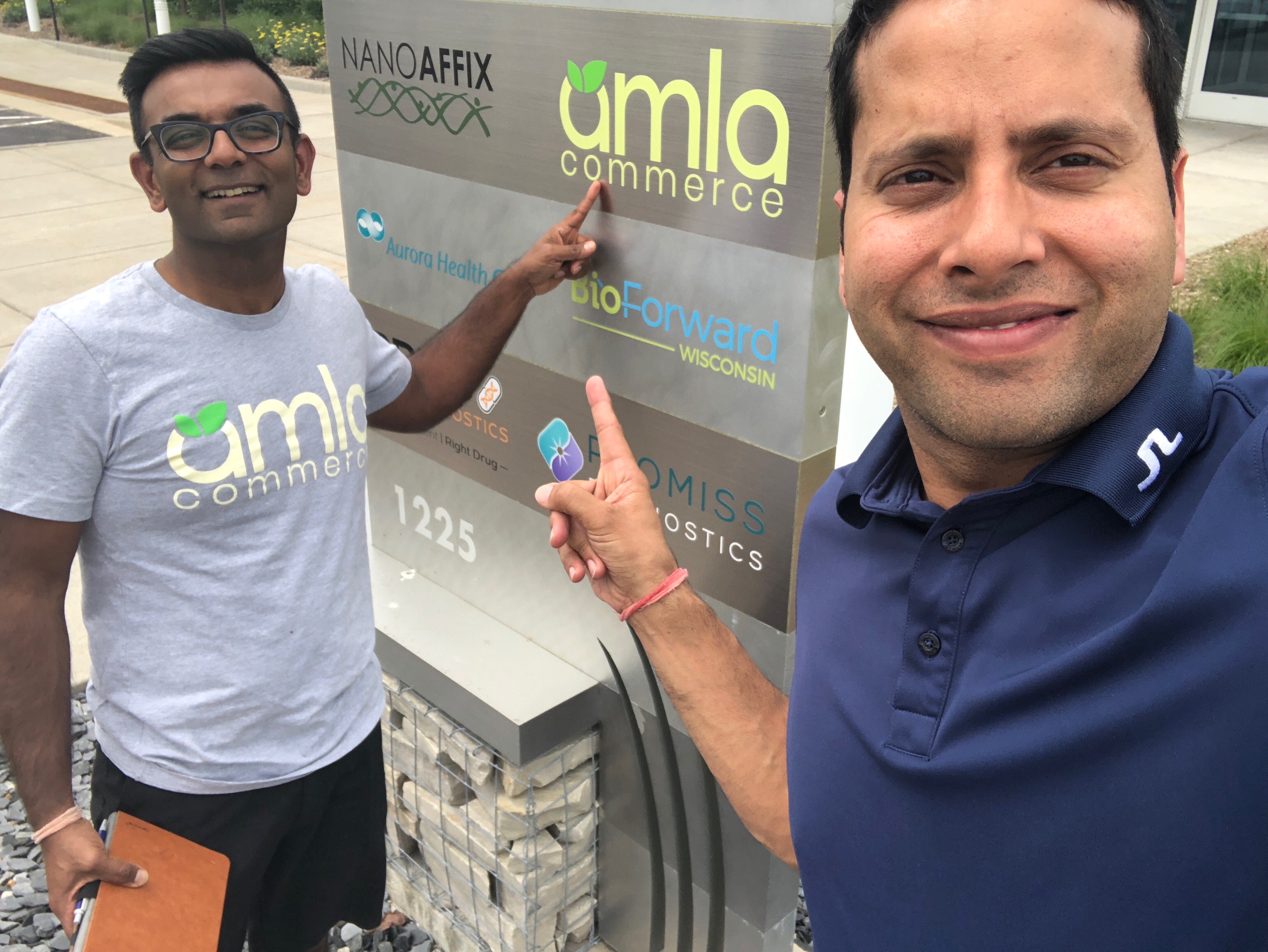 Photo of employees in front of an Amla office sign.