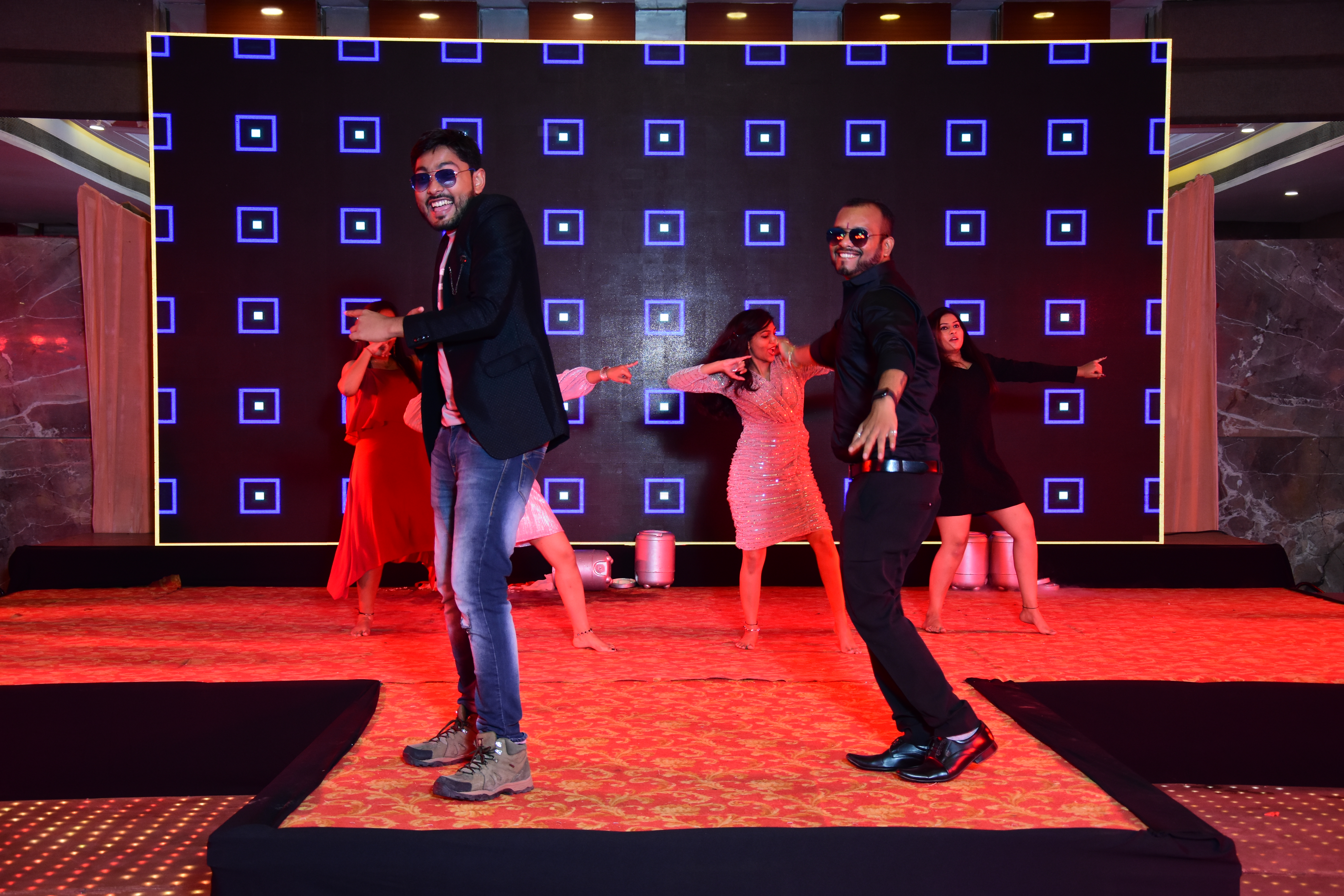 Photo of two dancers in sunglasses on stage.